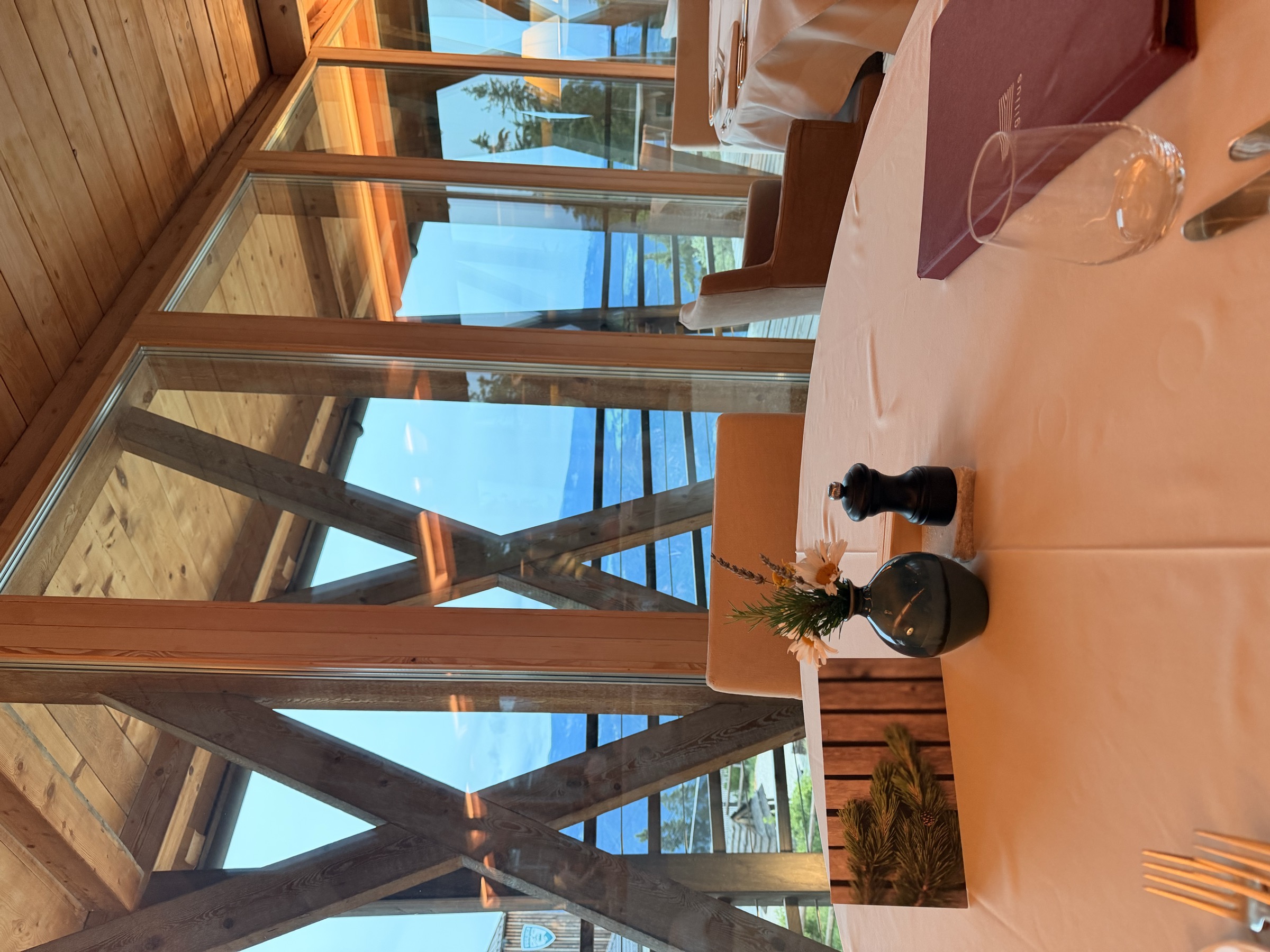 Restaurant 1500 at Vigilius Mountain Resort at dusk, table set with a view over the mountains